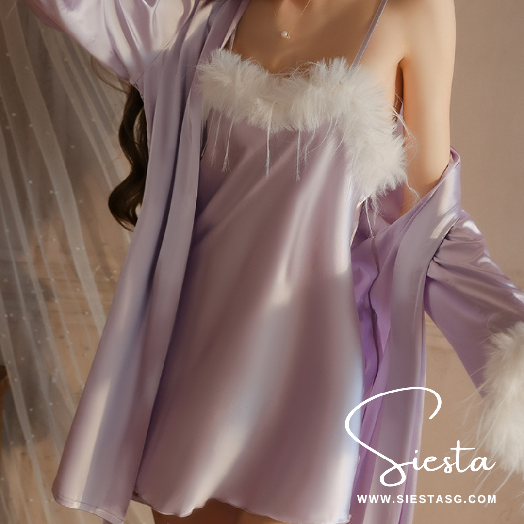 Purple satin dress with white feather details on a neutral background, featuring the brand 'Siesta'.